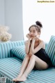 A woman sitting on a blue and white striped couch.