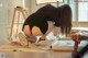 A woman kneeling on the floor with a drill in her hand.