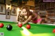 A woman in a bikini playing pool.