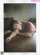 A woman laying on top of a wooden table.