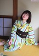 A woman in a kimono sitting on the floor.